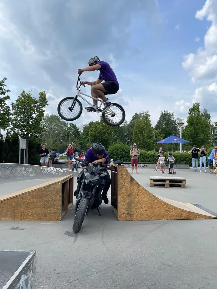 A BMX rider jumps over a motorcycle between ramps during the Ride The Future show in Warsaw.