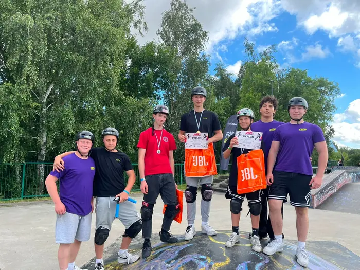 Participants with medals, certificates and JBL bags pose with the Ride The Future crew at the Tczew skatepark.